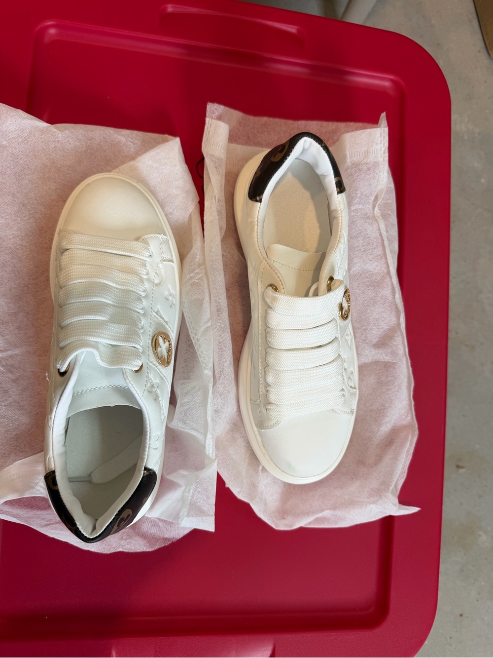 White Low-Top Sneakers with Black Heel Accent and Gold Emblem